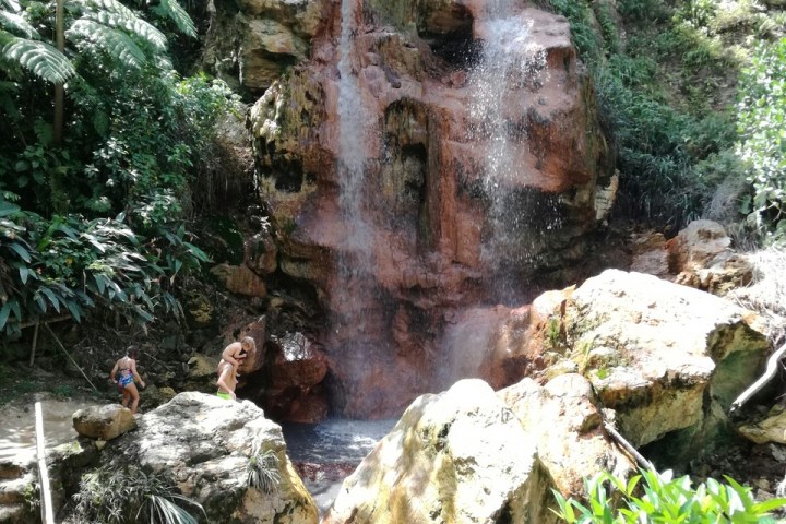 a large waterfall next to a rock
