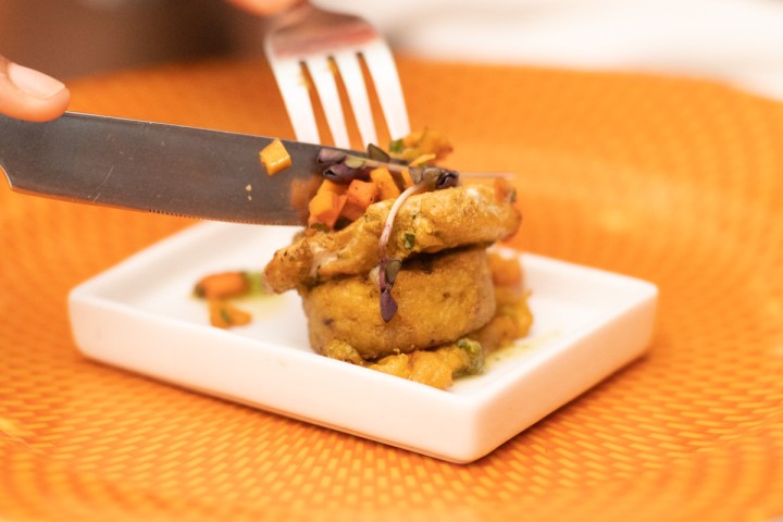 a person cutting a piece of cake on a plate